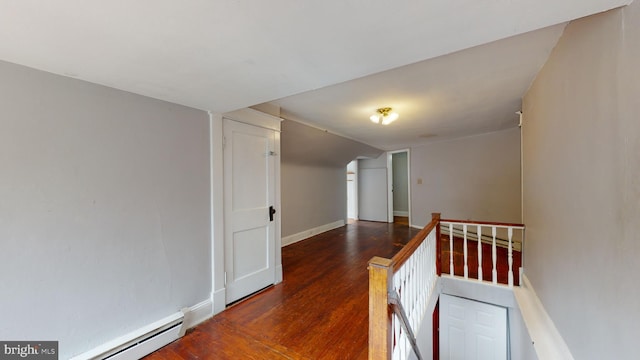 corridor with baseboard heating and dark hardwood / wood-style flooring