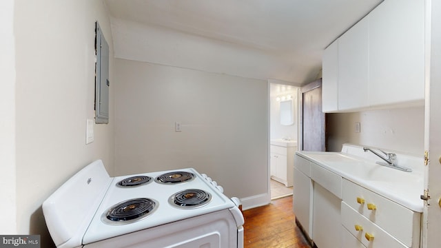 kitchen featuring range, light hardwood / wood-style flooring, sink, and white cabinetry