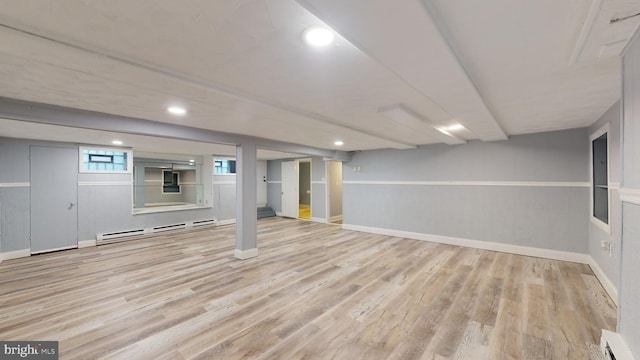 basement featuring a baseboard radiator and light wood-type flooring