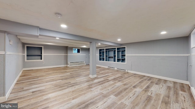 basement featuring a baseboard radiator and light wood-type flooring