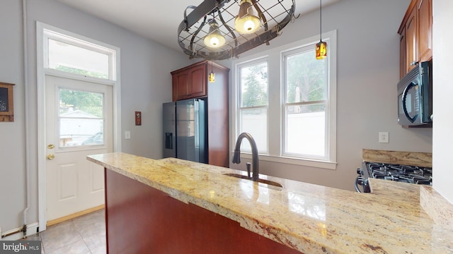 kitchen featuring pendant lighting, a wealth of natural light, stainless steel refrigerator with ice dispenser, and light tile floors