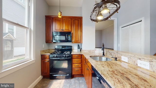 kitchen featuring pendant lighting, light tile floors, sink, light stone countertops, and black appliances