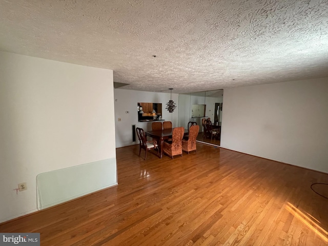 unfurnished dining area with a textured ceiling and wood finished floors