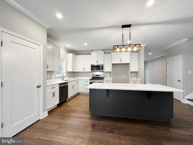 kitchen featuring white cabinets, pendant lighting, a kitchen island, and appliances with stainless steel finishes