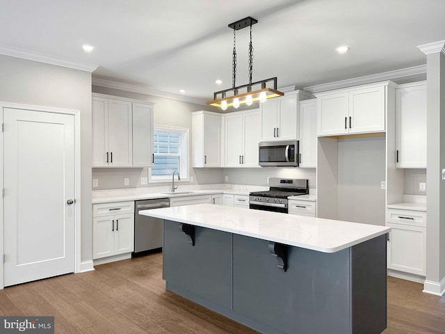 kitchen with dark hardwood / wood-style flooring, pendant lighting, stainless steel appliances, and white cabinets