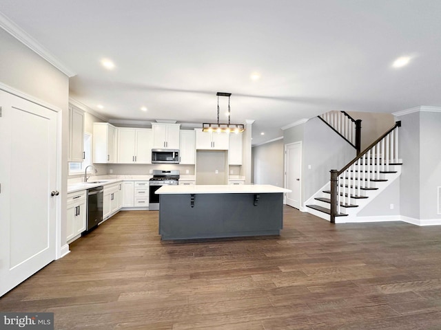 kitchen featuring decorative light fixtures, dark hardwood / wood-style flooring, white cabinets, stainless steel appliances, and a center island