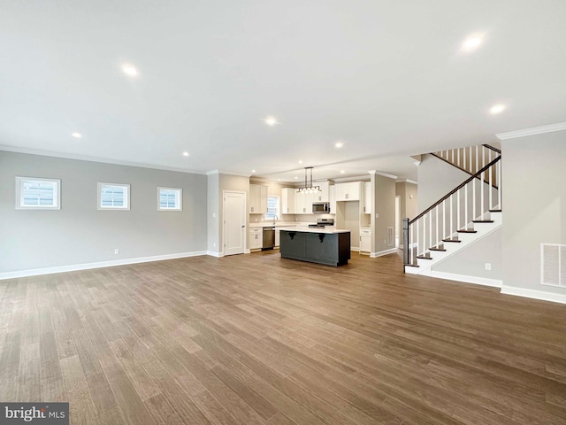 unfurnished living room with light hardwood / wood-style flooring, a notable chandelier, and ornamental molding