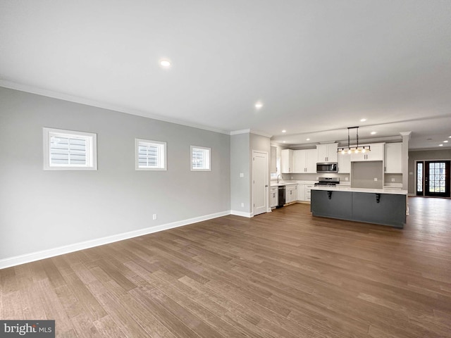 unfurnished living room with ornamental molding, hardwood / wood-style flooring, and sink