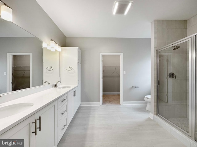 bathroom with dual vanity, tile flooring, toilet, and an enclosed shower