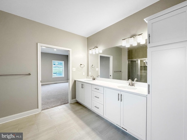 bathroom featuring double vanity, a shower with shower door, and tile flooring