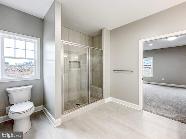 bathroom with toilet, tile flooring, an enclosed shower, and a wealth of natural light