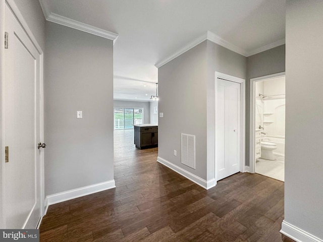 hall featuring ornamental molding and dark hardwood / wood-style flooring