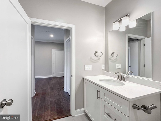 bathroom with oversized vanity, ornamental molding, and hardwood / wood-style flooring