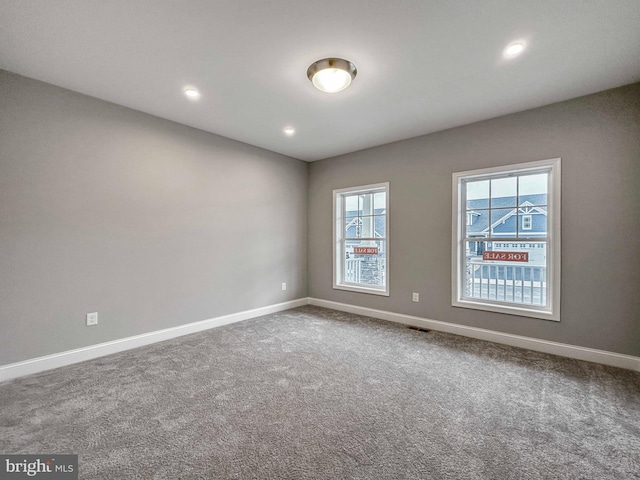 carpeted spare room featuring plenty of natural light