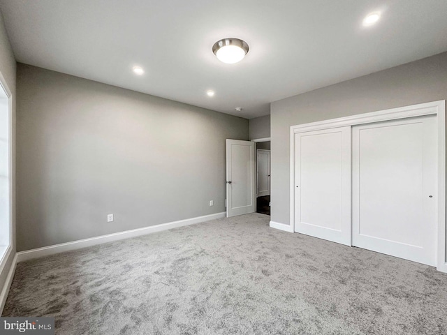 unfurnished bedroom with a closet and light carpet