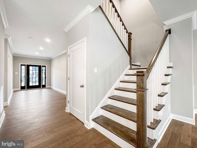 staircase with crown molding and dark wood-type flooring