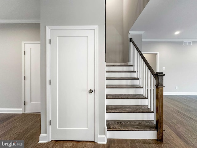 staircase with crown molding and dark hardwood / wood-style flooring