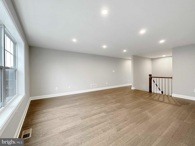 basement with plenty of natural light and light hardwood / wood-style floors