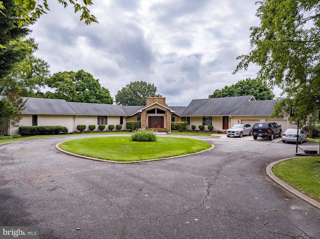 ranch-style home featuring a front yard and a garage