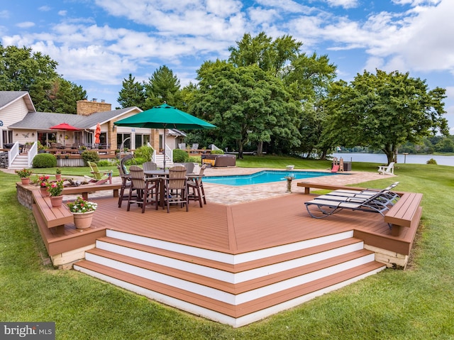 view of pool featuring a yard, a diving board, and a wooden deck