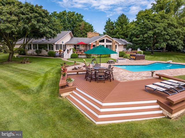 view of swimming pool featuring a lawn, a diving board, and a wooden deck