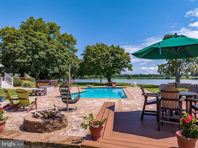 view of swimming pool with a patio and a deck with water view