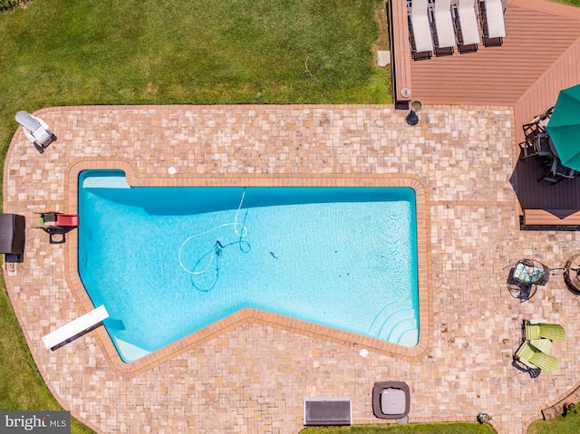 view of pool featuring a diving board and a yard