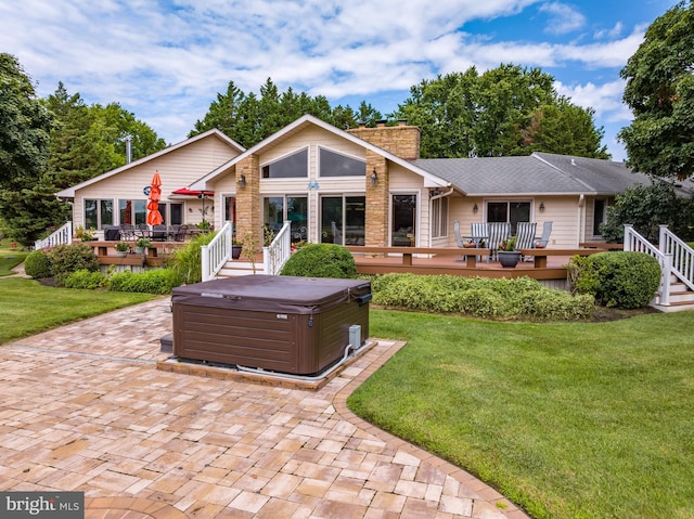 view of front facade featuring a deck, a hot tub, and a front yard