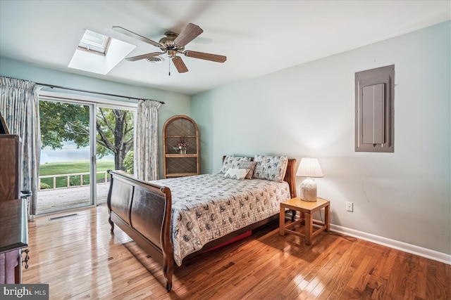 bedroom featuring access to exterior, ceiling fan, a skylight, and light wood-type flooring