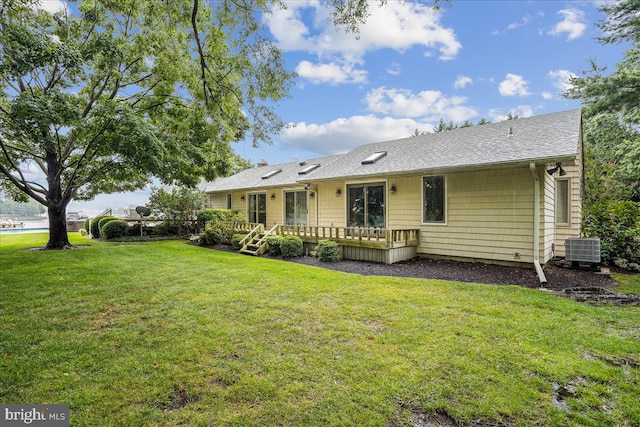 back of property featuring central AC unit, a deck, and a yard