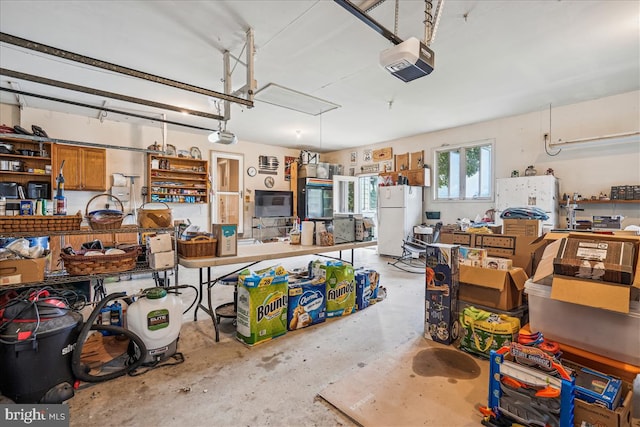 garage with a garage door opener and white refrigerator