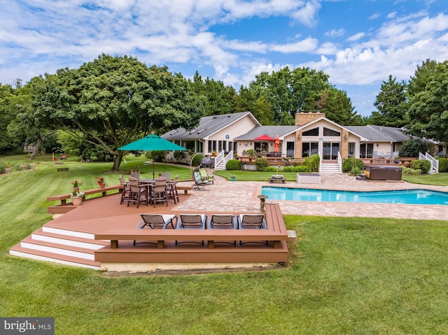 rear view of property with a lawn and a pool side deck