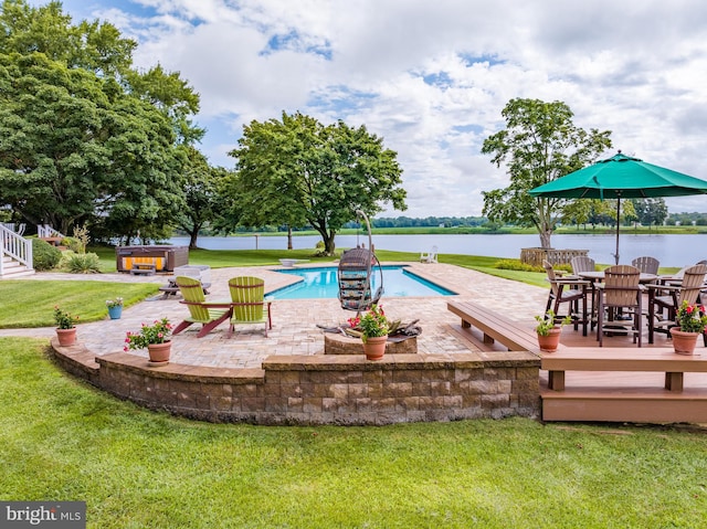 exterior space featuring a yard, a swimming pool with hot tub, and a patio