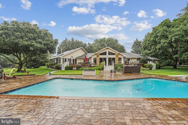 view of swimming pool with a diving board, a patio area, and a lawn