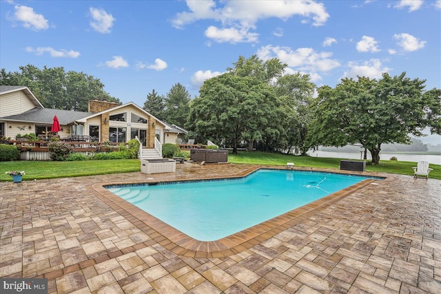 view of swimming pool featuring a yard, a patio area, and a deck