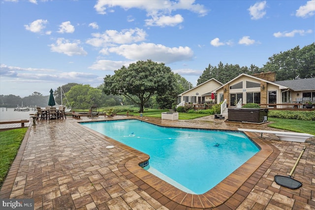 view of pool with a yard, a diving board, and a patio