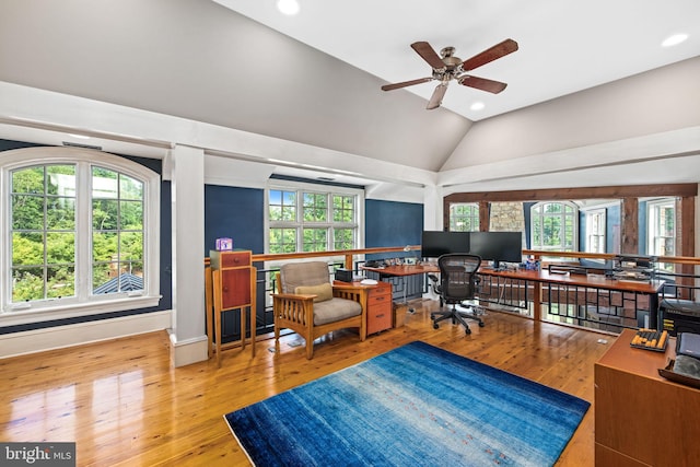 home office featuring hardwood / wood-style floors, ceiling fan, and vaulted ceiling