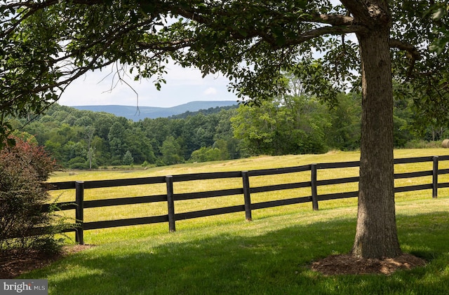 view of gate featuring a lawn, a mountain view, and a rural view