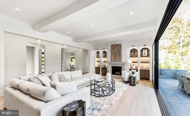 living room with light hardwood / wood-style floors and beamed ceiling