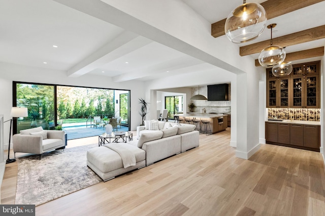 living room featuring beam ceiling and light hardwood / wood-style floors