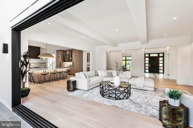 living room with beam ceiling and light hardwood / wood-style floors