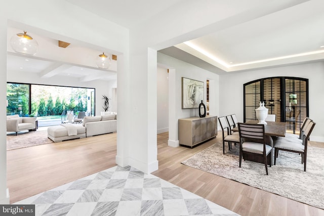 dining room featuring beam ceiling and light hardwood / wood-style flooring