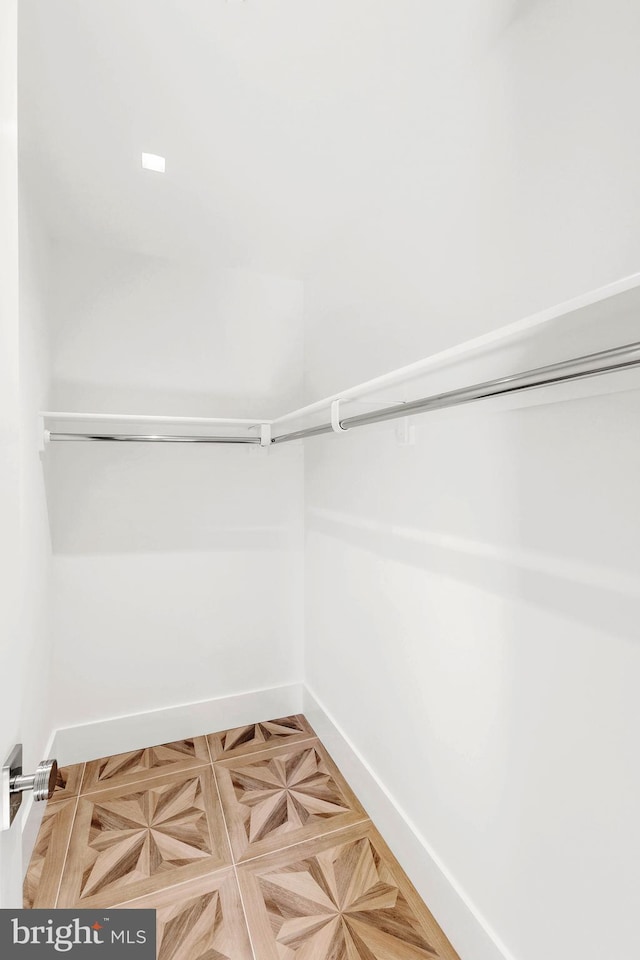 walk in closet featuring parquet floors