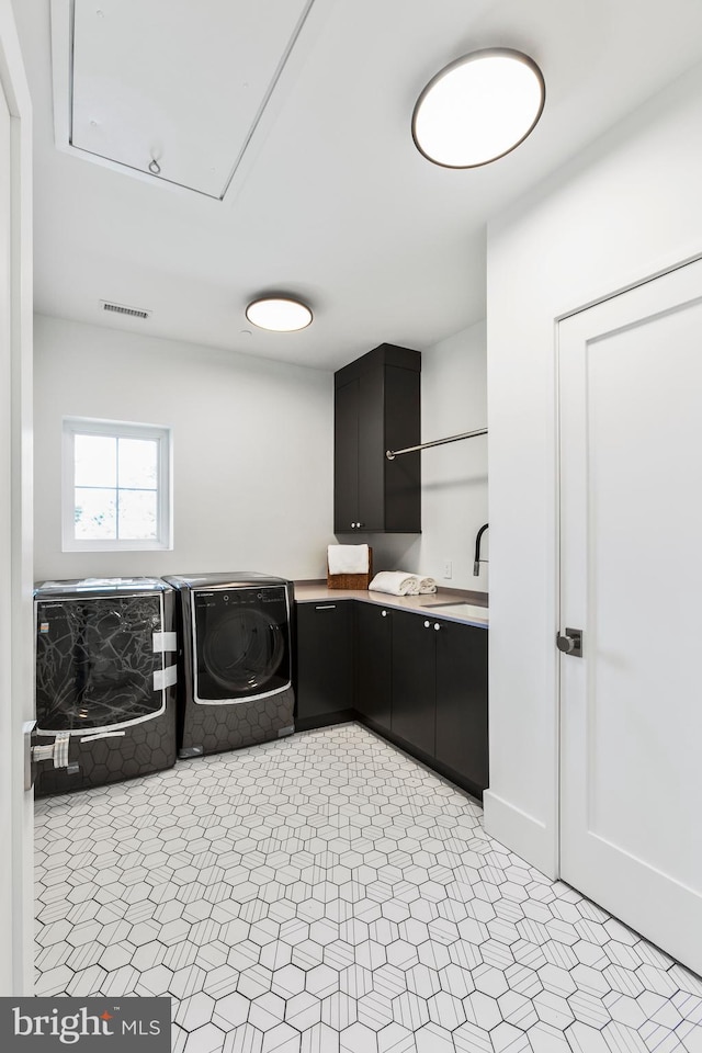 laundry area featuring cabinets, sink, and washer and clothes dryer