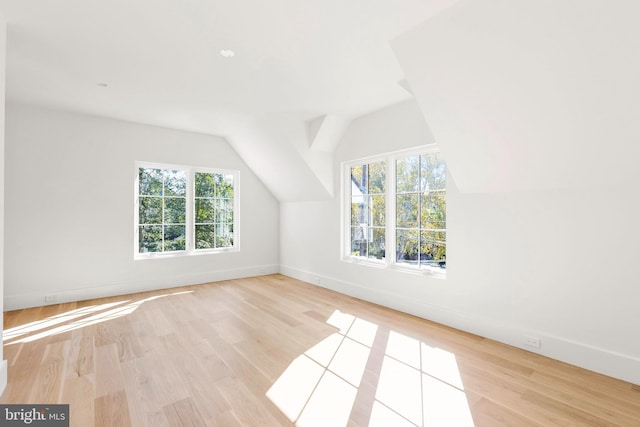 bonus room with light hardwood / wood-style floors, vaulted ceiling, and a wealth of natural light