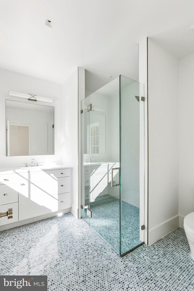 bathroom featuring vanity, toilet, tile patterned flooring, and a shower with door