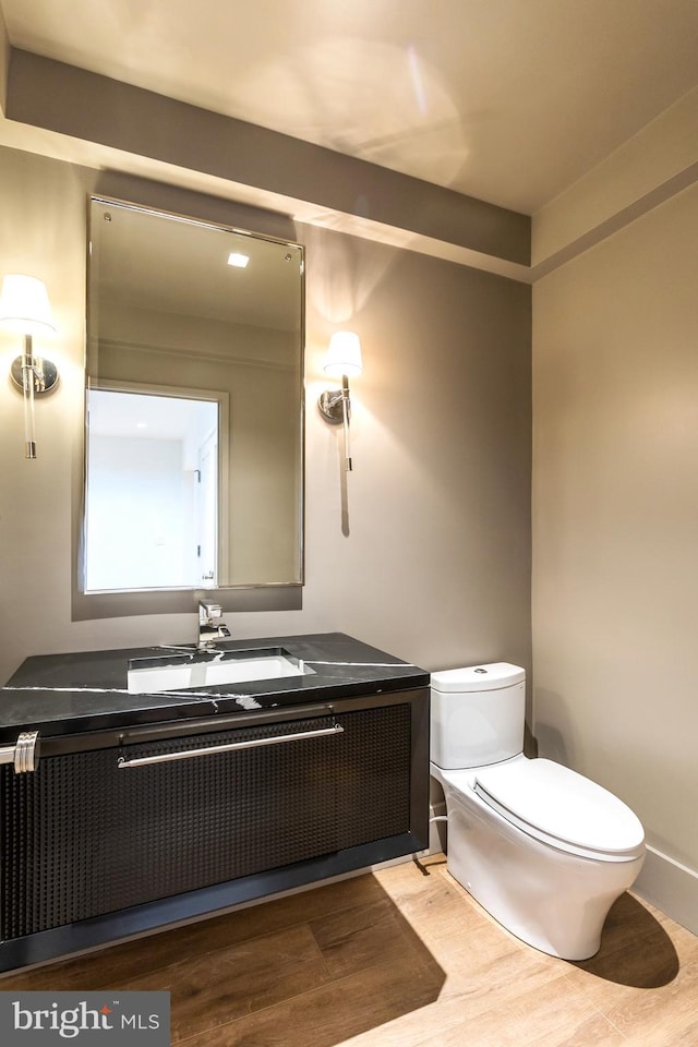 bathroom with vanity, hardwood / wood-style flooring, and toilet