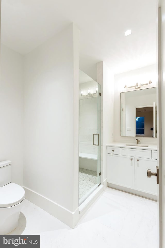 bathroom featuring vanity, toilet, and a shower with door