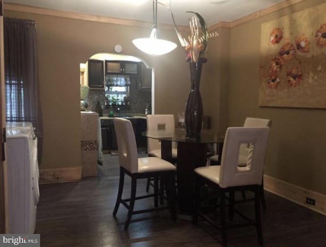 dining room with an inviting chandelier, washer / dryer, dark hardwood / wood-style flooring, and ornamental molding