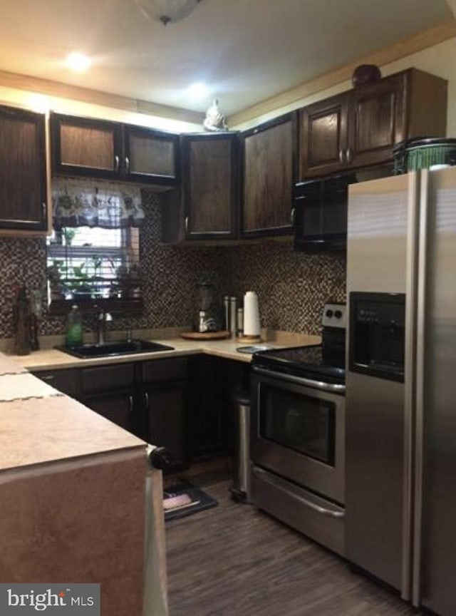 kitchen with appliances with stainless steel finishes, tasteful backsplash, dark hardwood / wood-style flooring, sink, and dark brown cabinets